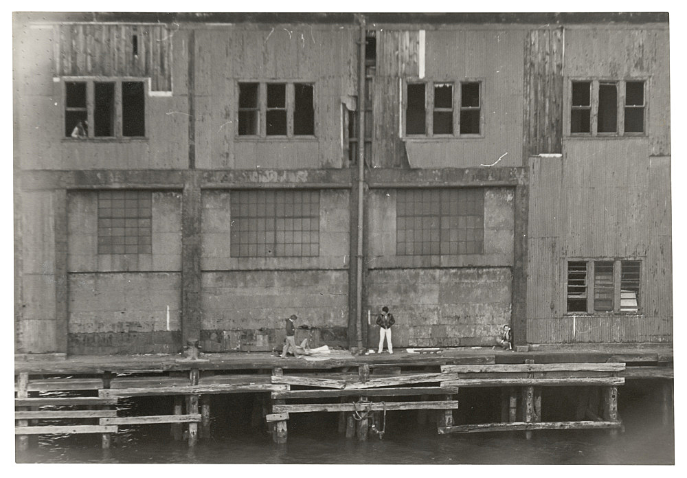 Alvin Baltrop – "The Piers (exterior with four figures)", n.d. (1975-1986) silver gelatin print 15.9 x 23.5 cm