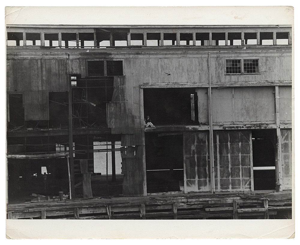 Alvin Baltrop – "The Piers (exterior view with figures)", n.d. (1975-1986) silver gelatin print image size: 16.8 x 24.8 cm paper size: 20.3 x 25.4 cm
